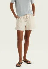 Short de lino color beige, de tiro medio con cintura elástica y cordón ajustable en tono crudo. Cuenta con bolsillos laterales.
