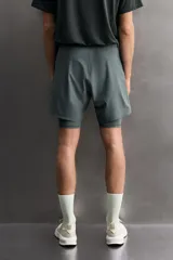 Pantalones cortos de entrenamiento 2 en 1 de Zara Athleticz, confeccionados en tejido técnico ligero y elástico. Presentan una malla interior integrada, cintura elástica con cordón ajustable, bolsillos laterales con cierre y aberturas en el bajo.