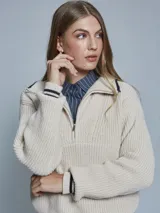 Sweater de tejido de punto grueso en color azul, con cuello alto y medio cierre frontal. Presenta detalles de rayas en contraste en los puños y el ruedo, con un diseño de corte holgado.