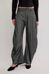 Pantalón de vestir gris con rayas finas, de silueta barrel, tiro medio, con cierre de cremallera y botón, y bolsillos.