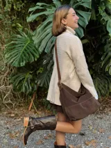 Botas de cuero color chocolate, de caña alta con detalle de hebillas y tachas.