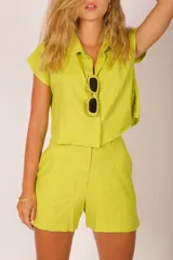 Short de lino verde lima, de tiro alto, con trabillas para cinto y bolsillos laterales.