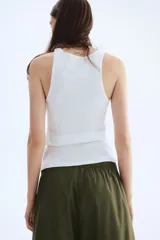 Pantalón de algodón color verde militar, de corte ancho y tobillero. Presenta cintura elástica fruncida y piernas amplias.