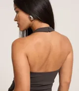 Blusa corta de bengalina negra con frente único, breteles anchos, recorte en el busto y cierre con botones en el cuello.