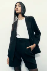 Bermuda negra con pinzas, tiro alto y corte a la rodilla.