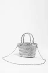 Bolso mini trenzado color dorado, con doble asa corta de mano y correa larga para el hombro. Incluye parche con logo grabado en el frente.