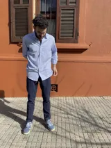 Camisa de hombre de algodón con estampado a cuadros en tonos rosado y celeste, corte clásico, manga larga, bolsillo en el pecho y botón en el cuello.