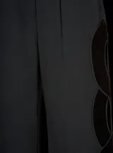 Pantalón negro de vestir de corte recto con cintura media y detalle de trenza de terciopelo calada en los laterales.