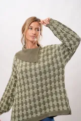 Buzo oversize de punto color verde oliva con cuello alto y diseño geométrico en dos tonos.