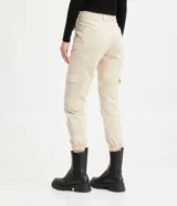 Pantalón jogger color beige, de sarga, con cintura elástica, bolsillos laterales tipo cargo y bolsillos traseros.