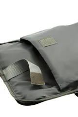 Mochila urbana con carcasa frontal rígida de color negro con diseño geométrico y logo 'VM' en blanco. Los laterales y la espalda son de tela gris jaspeada. Incluye un candado de combinación de tres dígitos integrado en el lateral.