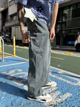 Jean de corte baggy con diseño de paneles laterales y costuras reforzadas, en tono gris lavado con efecto desgastado.