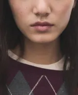 Sweater de punto con diseño de rombos en tonos bordó y gris, cuello redondo y mangas largas.