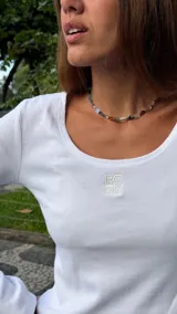 Top de manga larga en tejido acanalado color marrón, con escote redondo y logo bordado a tono en el centro del pecho.