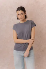 Remera tejida en seda fría color marrón, de calce relajado, cuello redondo y manga corta con terminación amplia.