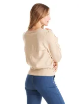 Buzo de tejido de punto gris, con cuello redondo, mangas largas con diseño de rombos calados y detalle de volado en los puños. Presenta hombros ligeramente fruncidos y terminaciones en rib acanalado.