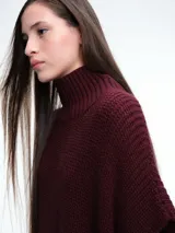 Chaleco tipo poncho de tejido de punto color tostado, con cuello polera y diseño holgado con laterales abiertos.