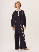 Pantalon de pierna ancha color negro, con franjas laterales en tonos beige y blanco, pretina elastica y bolsillos traseros.