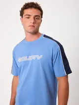 Remera negra de manga corta con diseño deportivo, parte superior de las mangas en color gris con ribete blanco y estampa frontal con la marca Rusty.