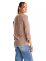 Blusa de rayón color marrón con escote en V y mangas tres cuartos acampanadas. Presenta detalles de bordado suizo y calados florales en los puños y en el ruedo asimétrico con terminación festoneada.