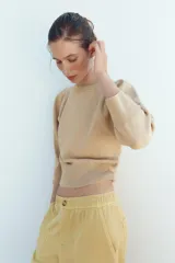 Jersey de punto color amarillo claro, con cuello redondo y mangas abullonadas.