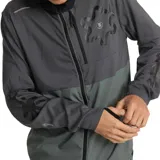 Campera deportiva gris con capucha negra, cierre frontal completo, bolsillo en el pecho con cierre y logo estampado en el hombro.