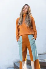 Pantalón de corte recto con diseño color block en tonos naranja, turquesa y beige. Presenta cintura alta y bolsillos laterales.