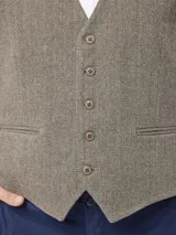 Chaleco sastrero de corte regular fit con diseño de espiga, escote en V y cierre frontal de botones. Cuenta con bolsillos frontales tipo ojal.