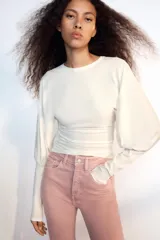 Jeans de tiro alto con cinco bolsillos, diseño cropped flare y bajo sin costuras. Cuenta con cierre frontal de cremallera y botón metálico.
