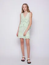 Blusa sin mangas de tela fluida con estampado floral en blanco y negro. Cuenta con jareta para fruncir en la parte delantera central.