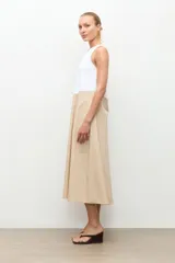 Maxi vestido largo de corte evasé, diseño bicolor con parte superior blanca y parte inferior beige, escote asimétrico de un solo hombro.