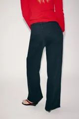 Jeans de tiro alto y estilo wide leg de Zara Woman Collection, confeccionados en denim negro con pespuntes en contraste. Presentan diseño de cinco bolsillos y cierre frontal con cremallera y botón.