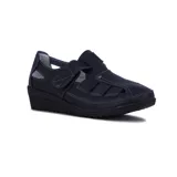 Guillermina casual modelo Wonder de color negro, confeccionada en cuero texturizado, con diseño cerrado en el empeine con aberturas laterales, tira con cierre de velcro ajustable y suela de goma con taco enterizo.