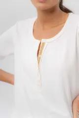 Remera de algodón con spandex, color blanco, de manga corta y cuello redondo con cartera delantera de botones y detalle en cordón de lana en contratono.
