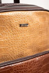 Mochila marrón con estampado de piel de cocodrilo, con cierre superior y bolsillo frontal con cierre.