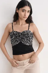 Top negro con escote corazón y tirantes finos, decorado con lentejuelas plateadas en la parte superior y frunce en el frente.