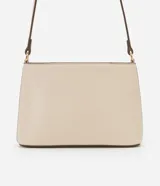 Cartera bandolera pequeña de material sintético color beige con detalles en marrón oscuro. Cuenta con cierre superior por cremallera, asa larga ajustable y placa metálica dorada con el logo de la marca en el frente.