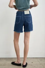 Short de tiro medio color marrón, con corte recto y terminación de ruedo deshilachado.