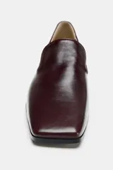 Mocasines de piel color marrón con copete subido, tacón medio en bloque y punta cuadrada.