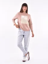 Remera de manga larga color beige, con cuello redondo y estampado frontal que dice "Magic is something you make" en color lila.