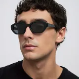 Lentes de sol con montura heptagonal de diseño angular y estilo oversize, en color negro total con lentes polarizadas.