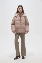 Campera puffer de corte holgado, color beige, con capucha desmontable, cierre frontal y puños elásticos.