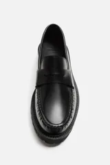 Mocasín de vestir fabricado en piel de alta calidad con detalle de antifaz en el empeine, horma redonda y suela track con ligero volumen.