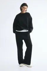 Buzo oversized negro con interior cepillado suave, cuello redondo con ribete acanalado, hombros caídos y puños y bajo con ribete acanalado.