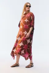 Kaftan maxi amplio de color amarillo, con escote redondo, mangas cortas y ruedo irregular. Presenta un diseño estampado a cuadros con efecto teñido.