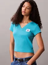 Remera de Calvin Klein confeccionada en punto de algodón elástico con textura de canalé fino. Presenta un diseño de corte slim, cuello en V, manga corta y una insignia con el logo de la marca en el pecho.