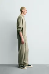 Pantalón relaxed fit tejido en hilatura de algodón con estructura, color verde militar. Presenta cintura elástica ajustable con cordón en contraste, bolsillos de vivo frontales y detalle de bolsillo trasero.