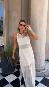 Vestido largo de red color blanco roto, sin mangas y con tajo lateral. Se usa sobre otra prenda interior.