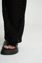 Pantalón negro de tejido calado con cintura elástica.