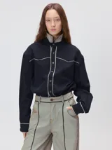 Pantalón sastrero de tiro medio y pierna ancha, con diseño a rayas verticales finas y detalle de vivos negros en la pretina y a lo largo del frente.